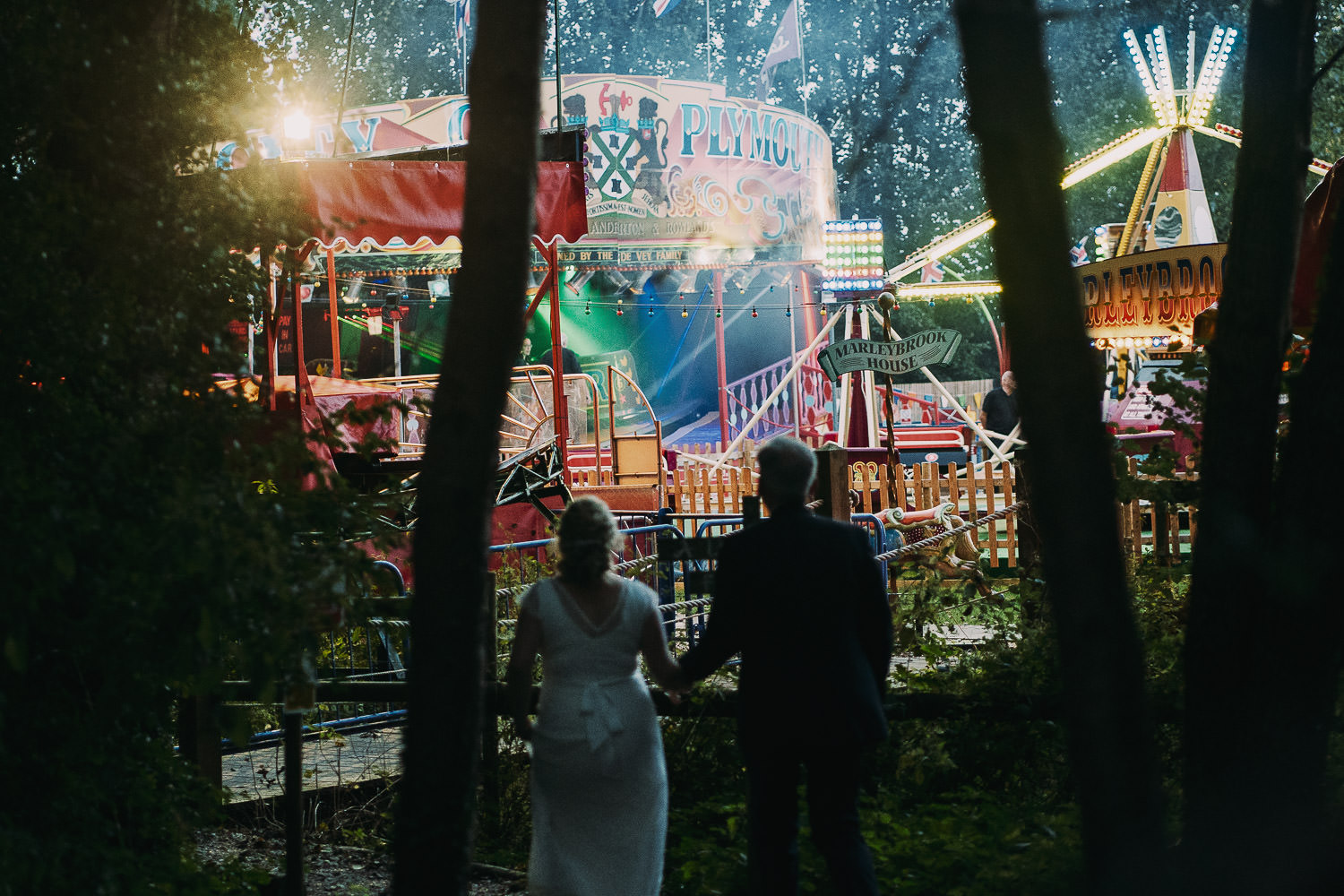 bride and groom walking to funfair