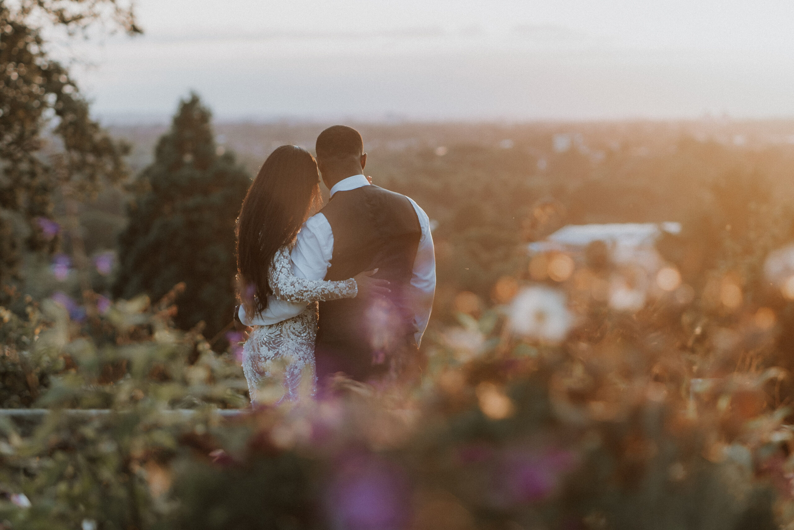 Bride & Groom embracing during golden hour with breathtaking sunset view at Pembroke Lodge in Richmond Park